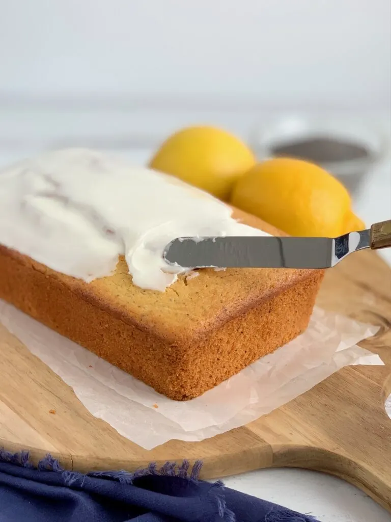 Glazing a lemon poppy seed loaf with a powdered sugar and lemon juice icing.