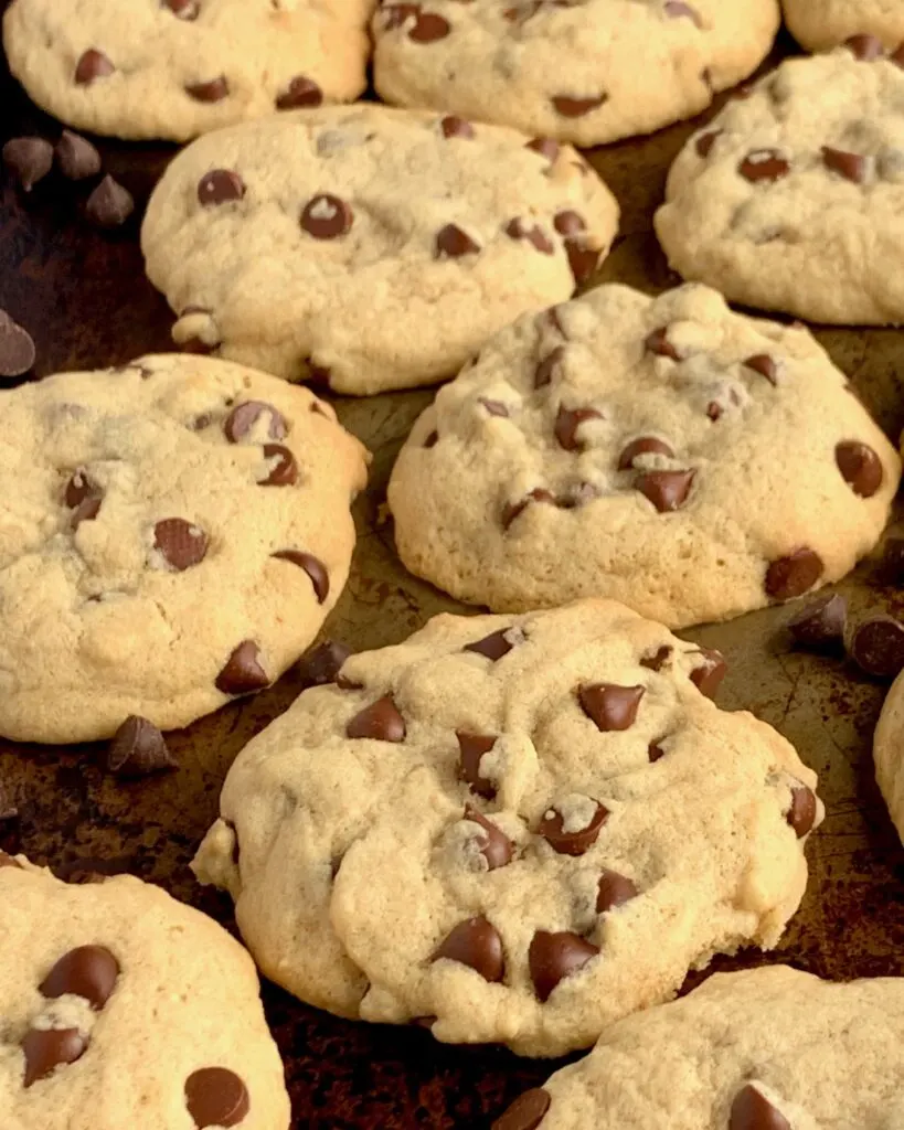 Baked chocolate chip cookies on a cookie sheet.