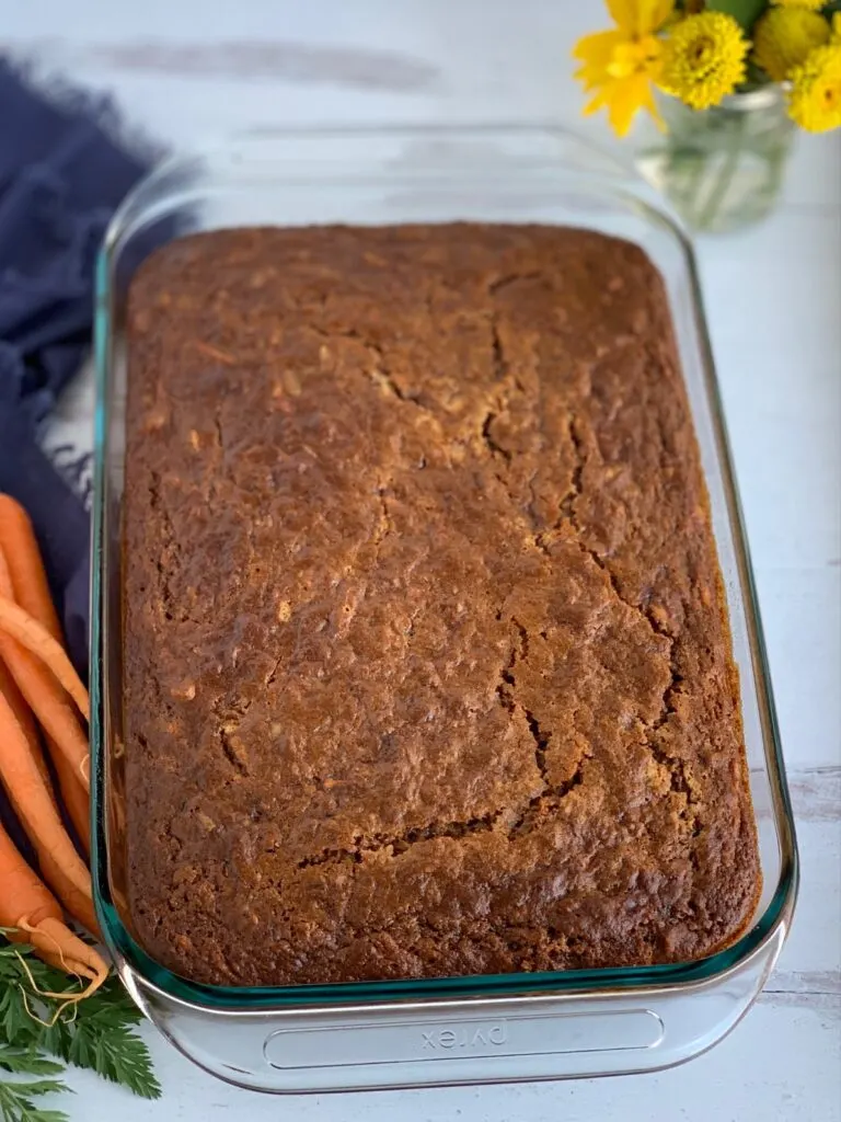 A moist looking carrot cake in a 9 x 13" baking pan with no frosting on it yet.