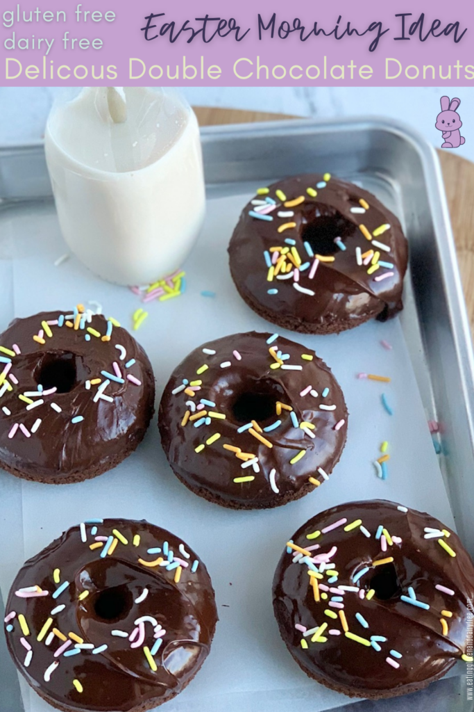 A try of 5 chocolate donuts topped with chocolate ganache. Then topped with festive Easter sprinkle colors next to a bottle of almond milk.