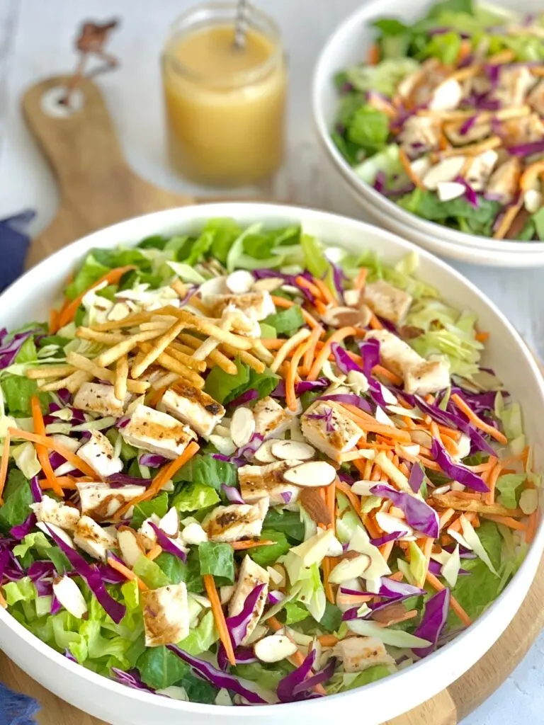 a large salad with greens, sliced carrots, toasted almond slivers, and grilled chicken