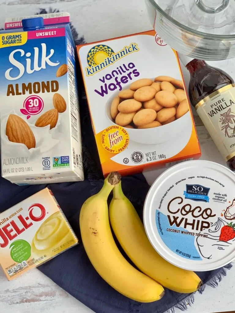 The ingredients for this recipe-- dairy free milk, vanilla wafers, vanilla extract, 2 bananas, Instant Jell-O, and Cocowhip on the kitchen counter.
