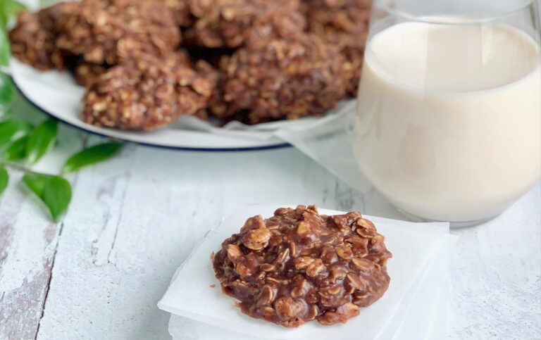 A close up of a No Bake Cookie with chocolate and peanut butter mixture over oats next to a big glass of milk.
