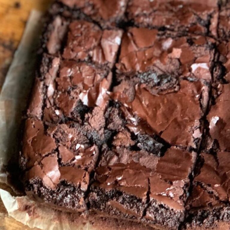 An 8x8-inch square pan of baked brownies on a cutting board.
