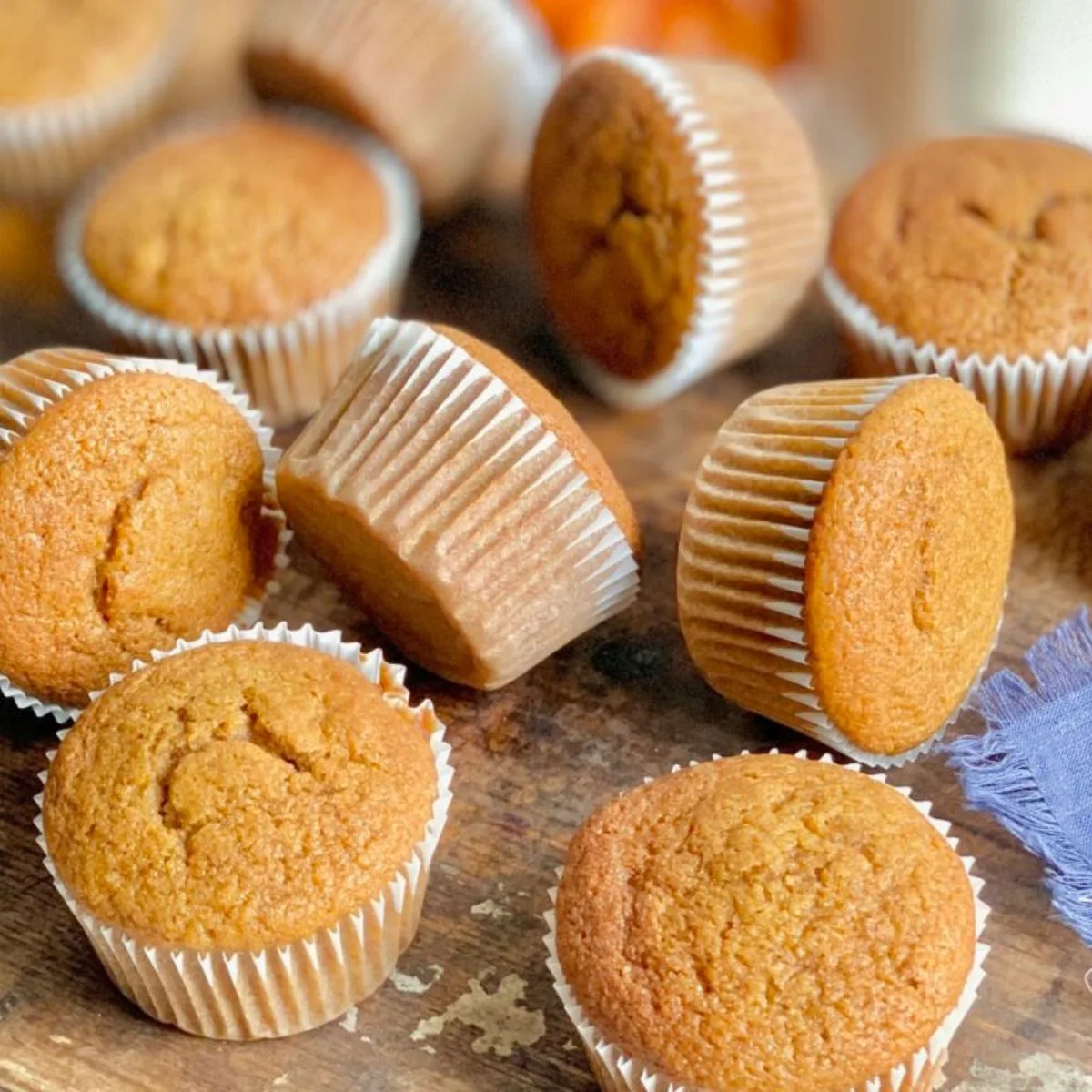 A few pumpkin muffins sitting on a plate, a few on their sides.