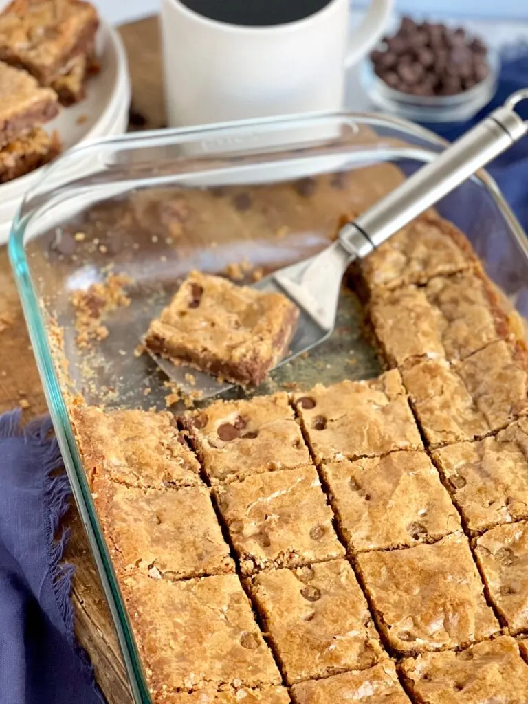 A 9x13-inch baking pan filled with cut golden brown treats with chocolate chips.