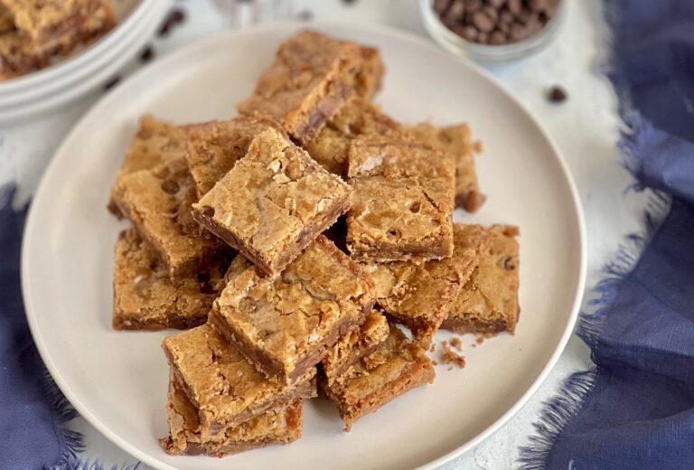 A plate stacked with square cut golden colored bars.