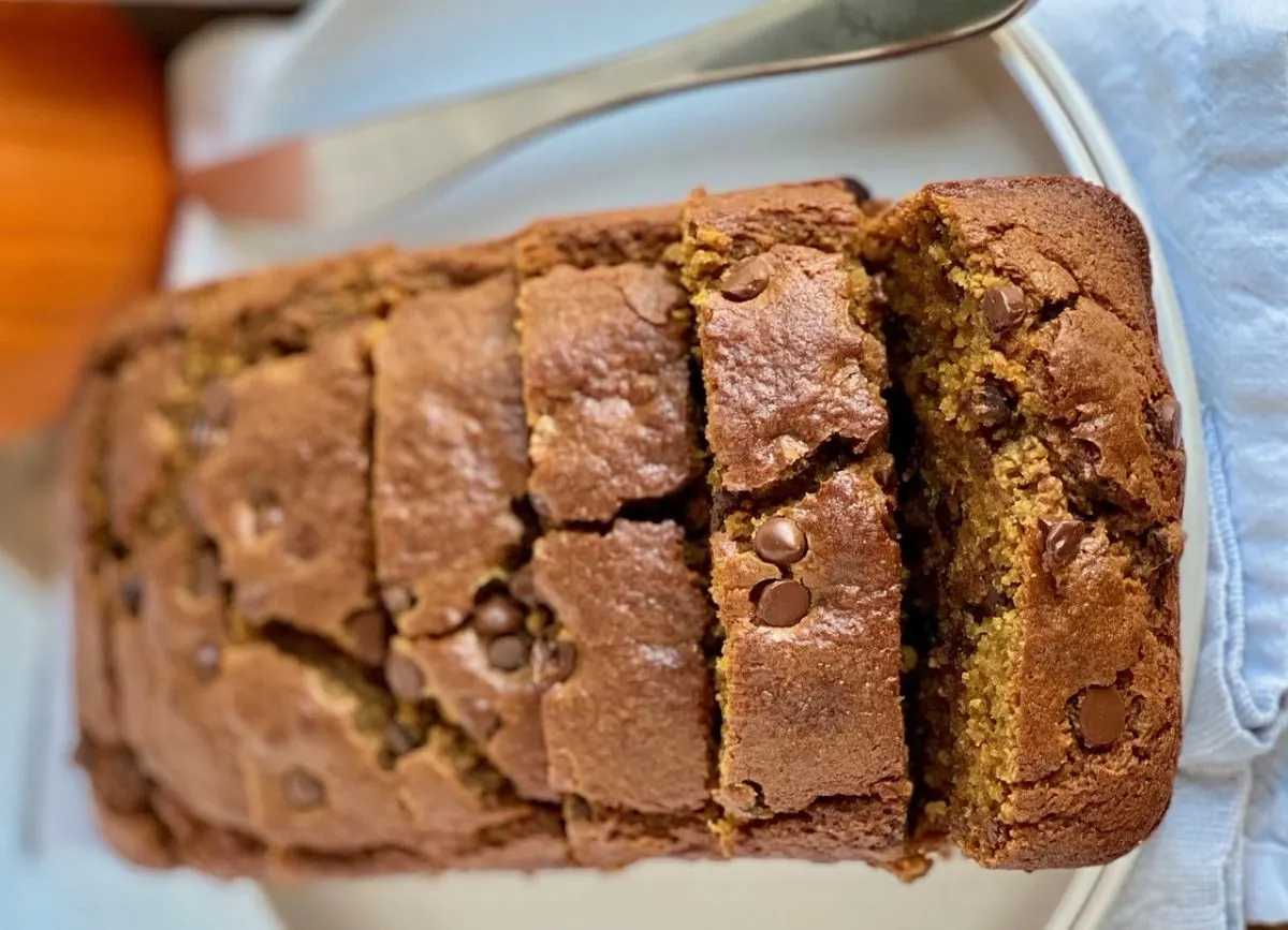 Looking down on a loaf of gluten-free pumpkin chocolate chip bread that has been sliced into individual slices.
