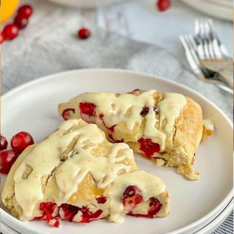 Two gluten free dairy free cranberry orange scones on a dessert plate.