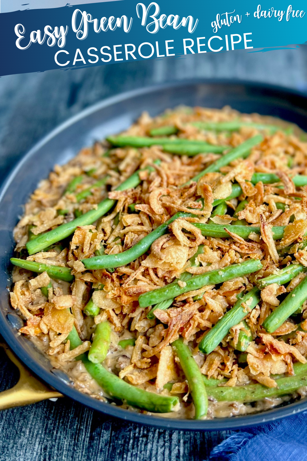 A black skillet with long green beans, a creamy thick mushroom soup, and fried crispy onions.