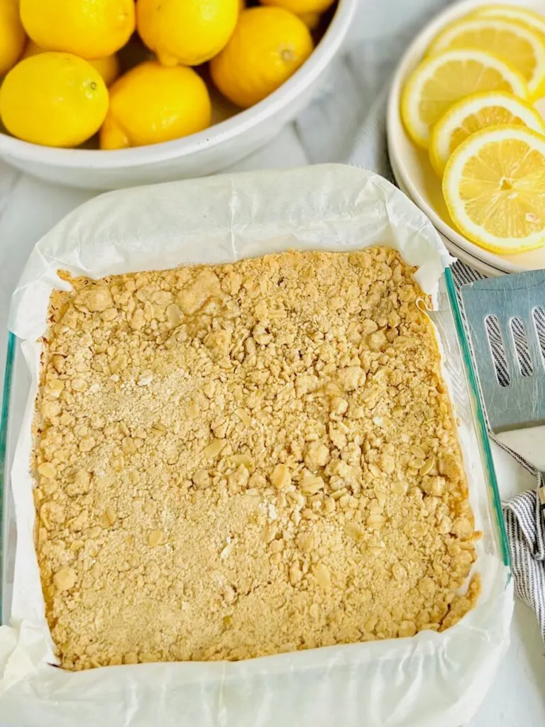  A 9x9-inch glass dish filled with a top crumbly layer of oats and other ingredients.