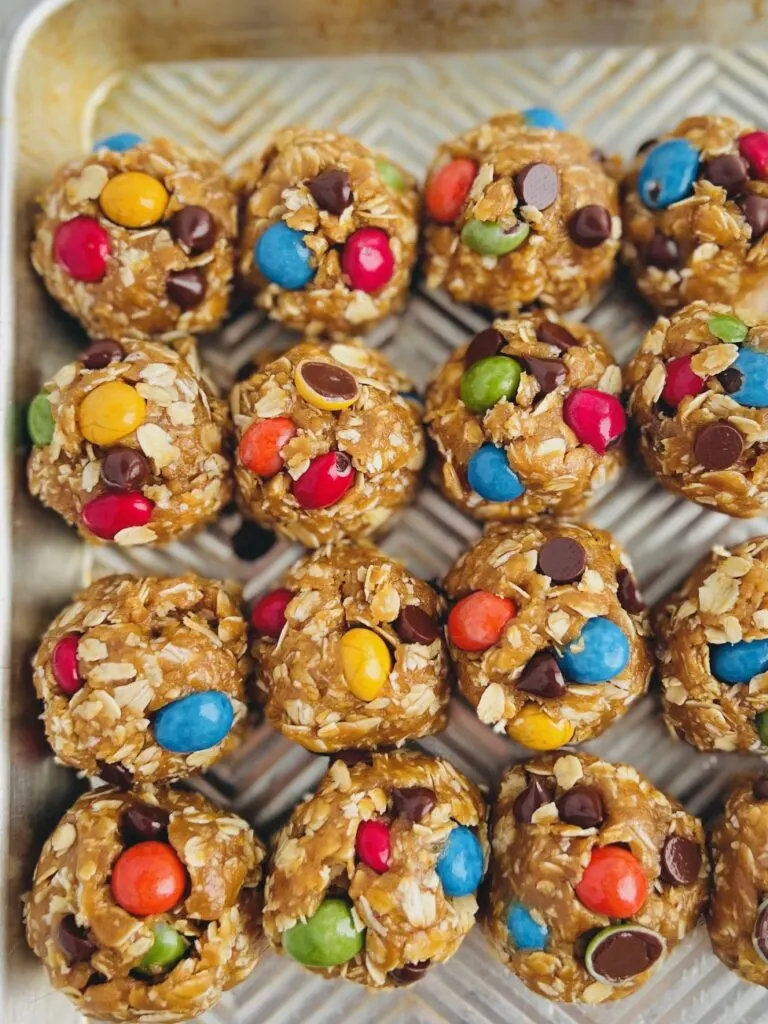 A cookie sheet with with round balls of cookie dough