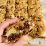 A hand holding a Gluten Free Dairy Free Chocolate Chip Cream Cheese Bar.