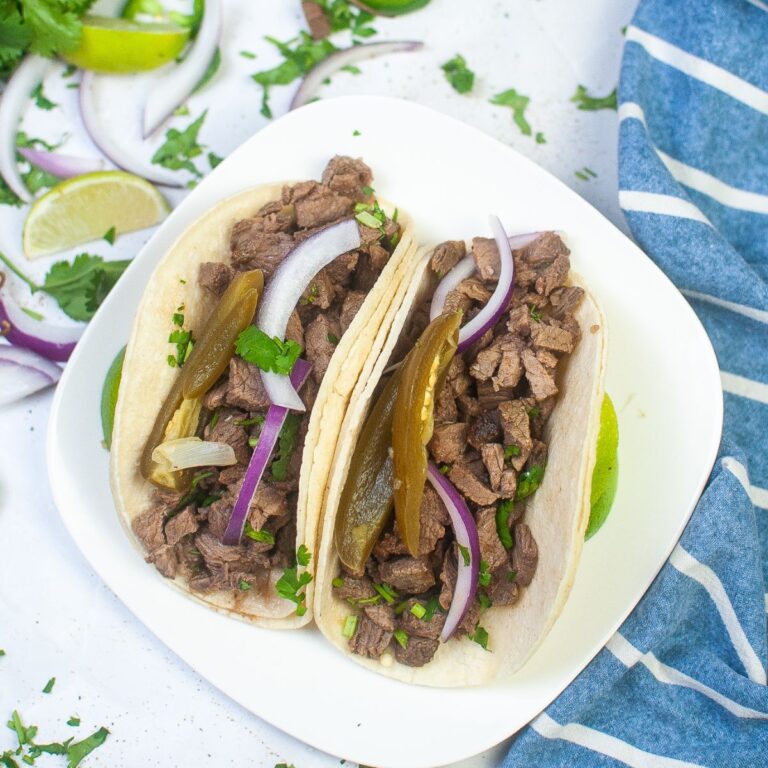 A square white plate with Street Tacos on it.