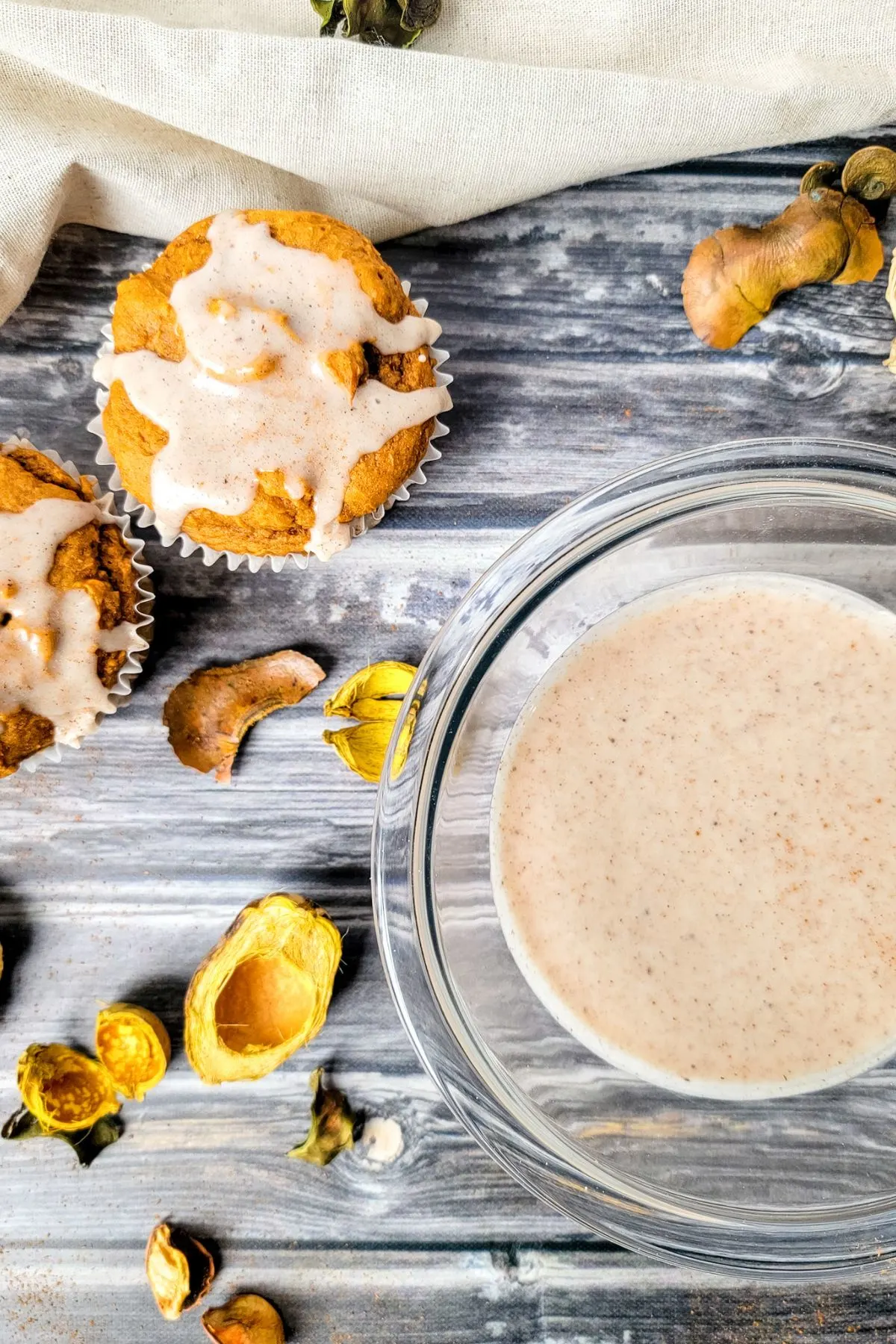 Bowl of dairy free sugar cinnamon glaze and muffins with glaze on top.