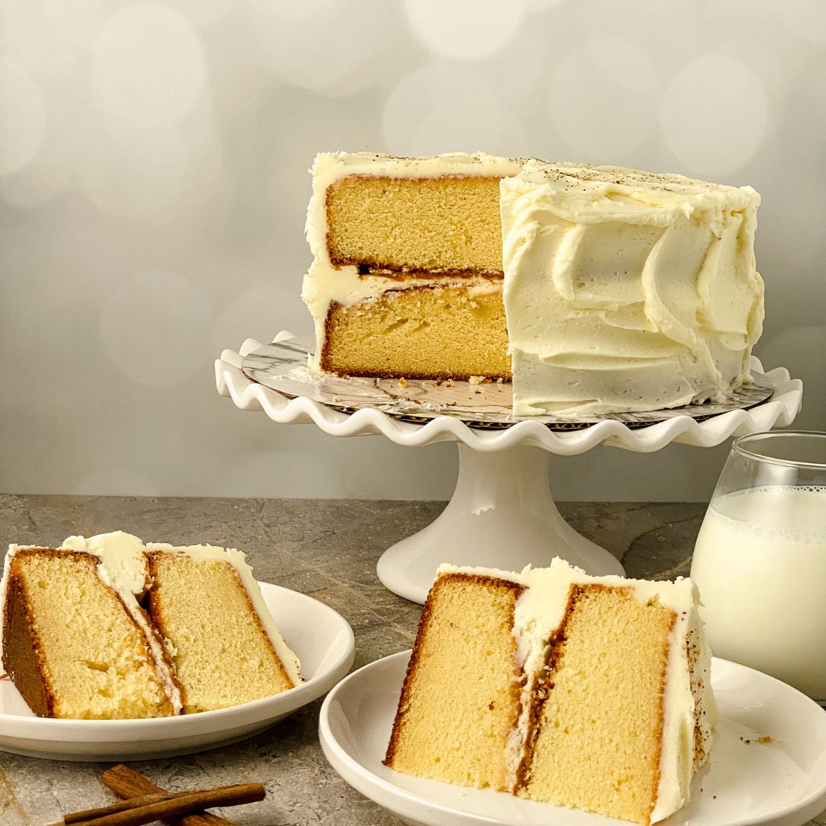 Two slices of cake from an eggnog cake on a pedastal.