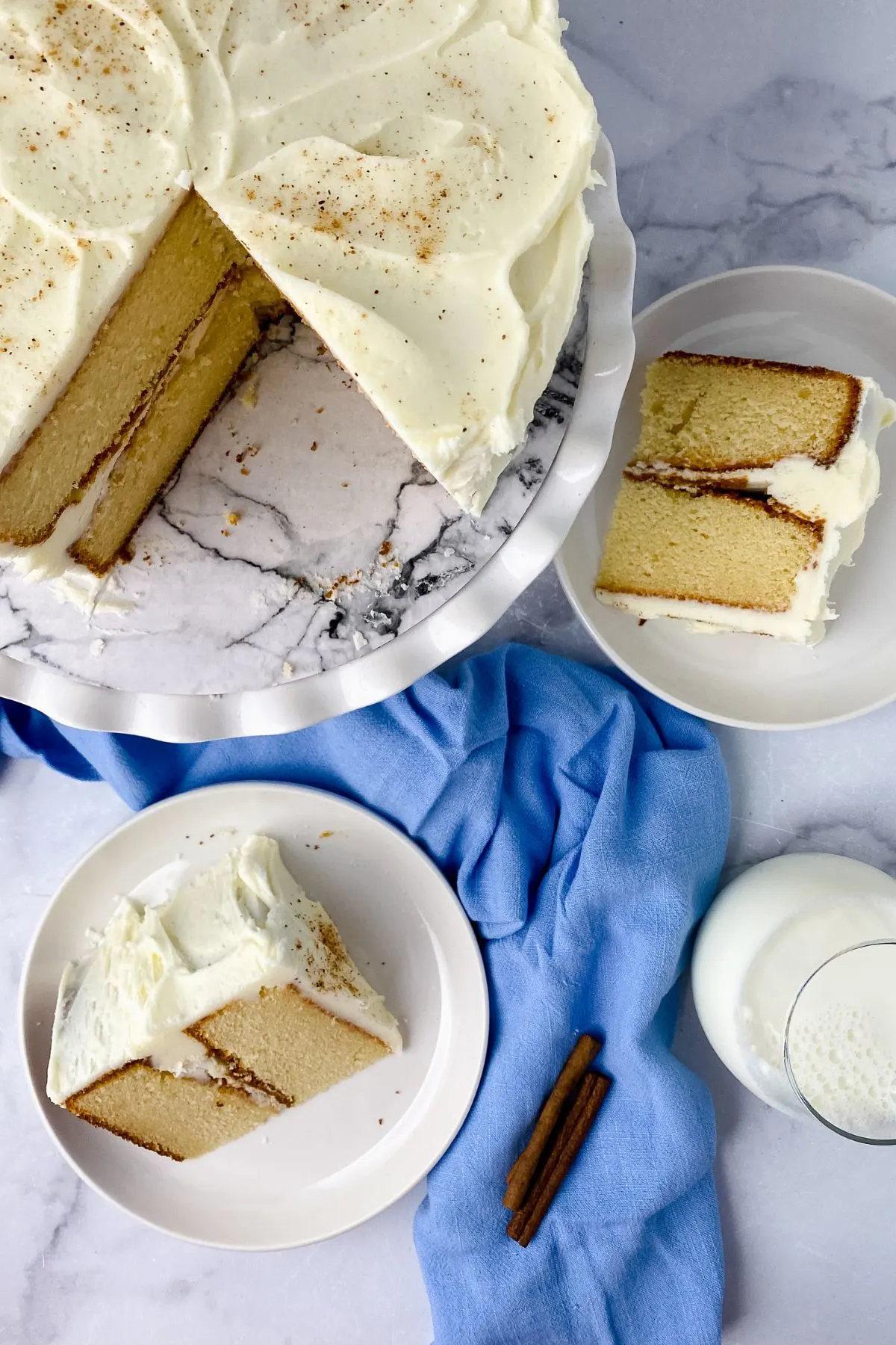 Looking down on eggnog cake with slices on plates.