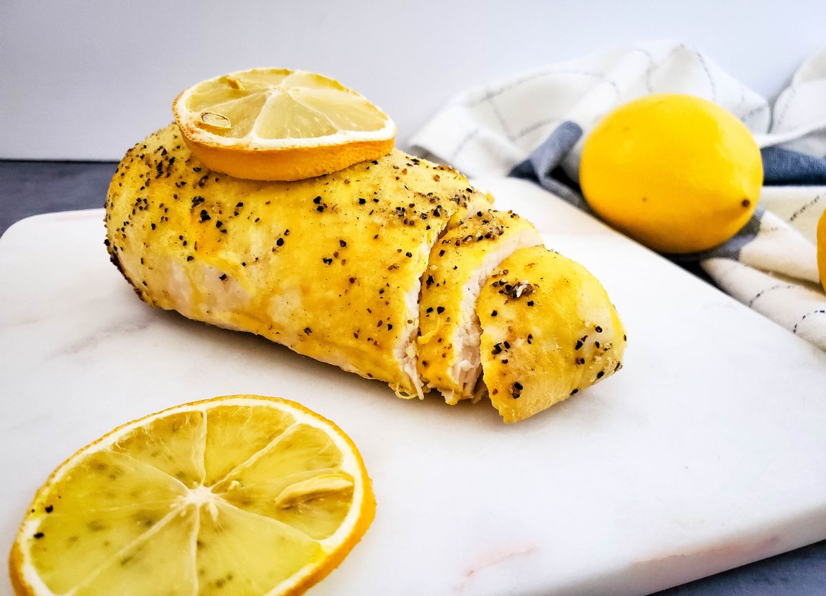 Cut up piece of chicken with lemon slices.