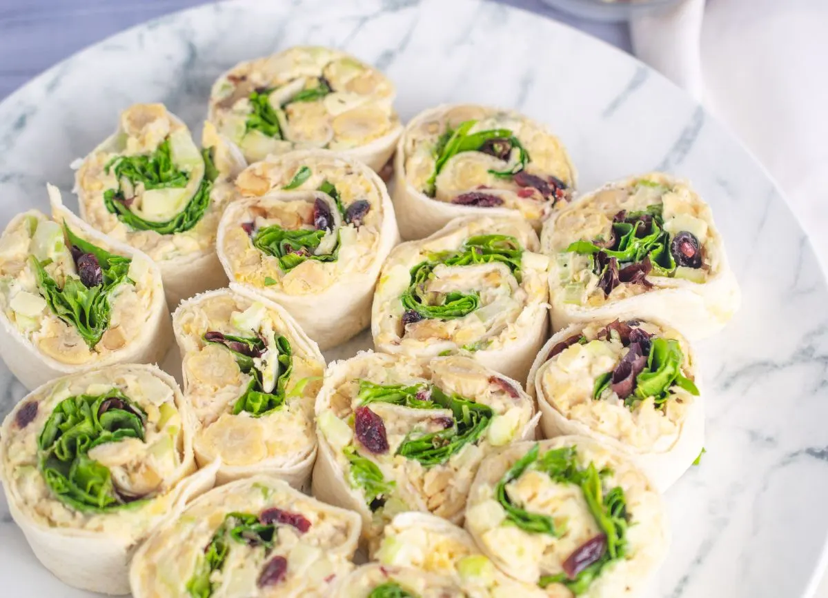 A plate of cranberry apple, walnut, chickpea salad pinwheels on a plate.