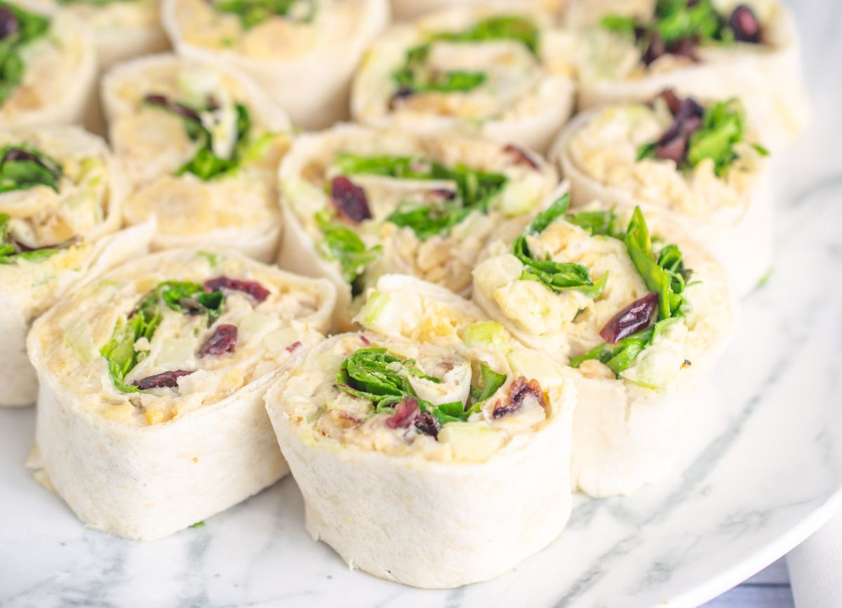 A plate full of dairy free apple chickpea salad pinwheels.