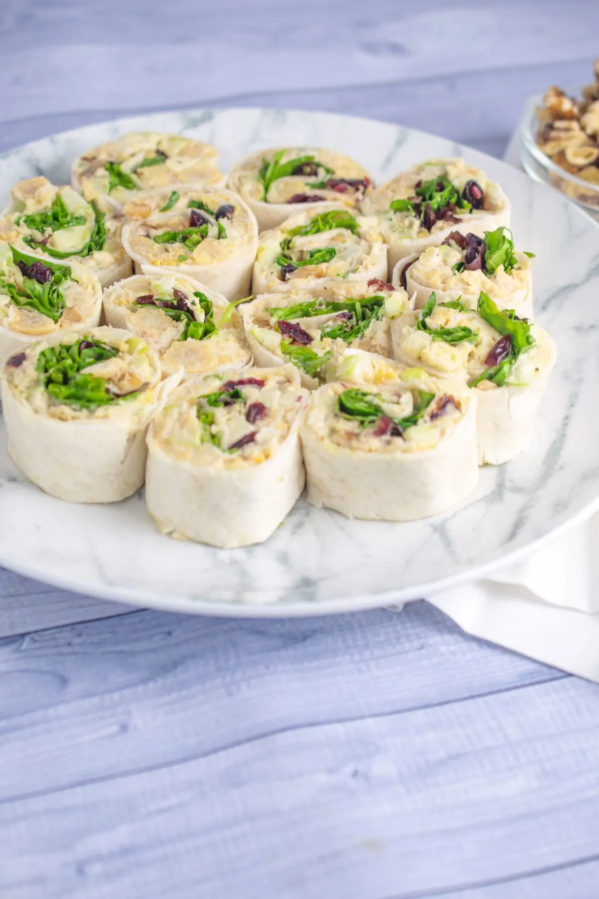 Chickpea cranberry apple walnut pinwheels on a plate.