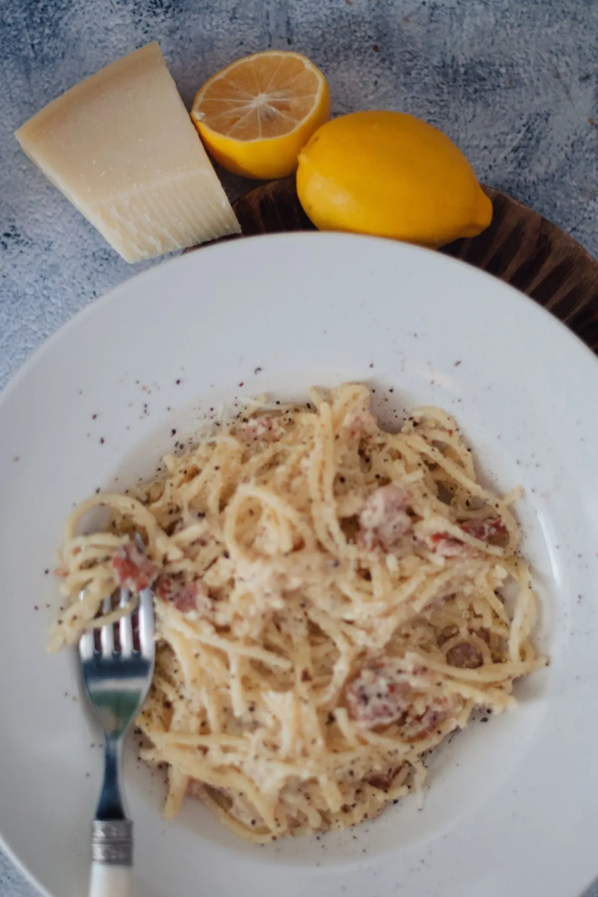 Plate of pasta carbonara with fork in pasta.