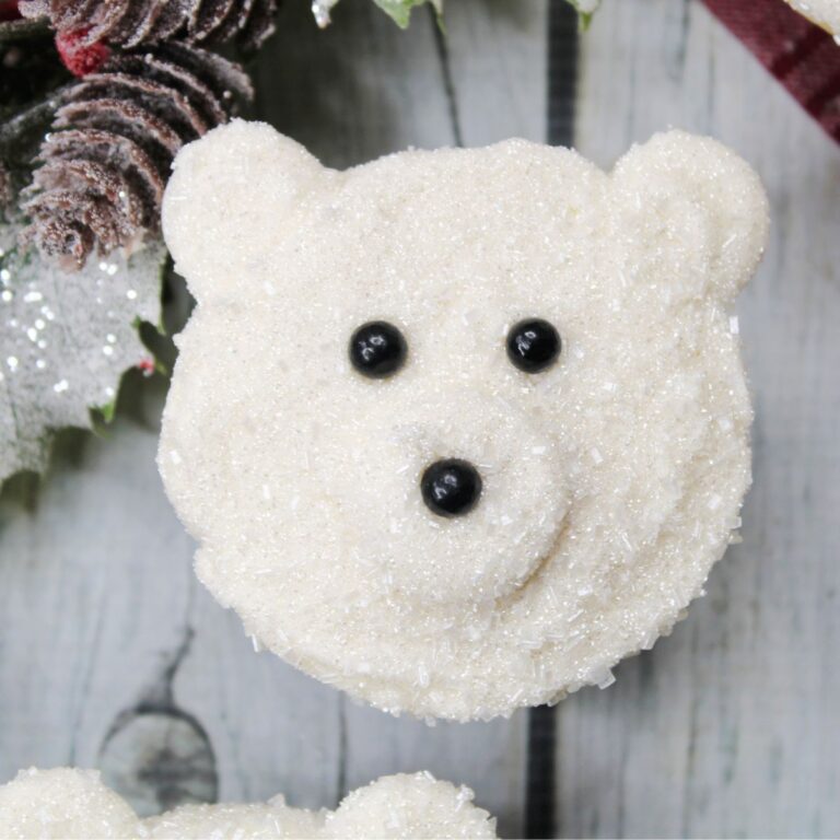 Looking down on a close-up of a polar bear a cupcake.