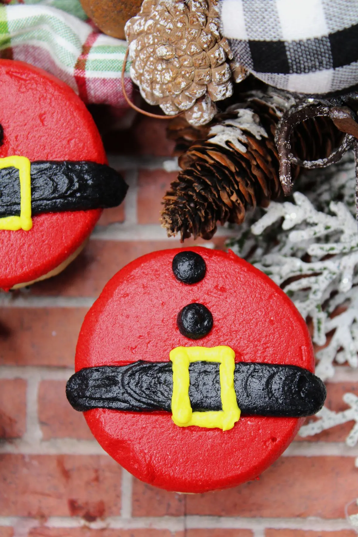 Looking down on a cupcake with a Santa belt and two dots for his coat on a cupcake.