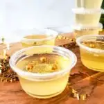 A close up of a Champagne Jello Shot with gold sprinkles.