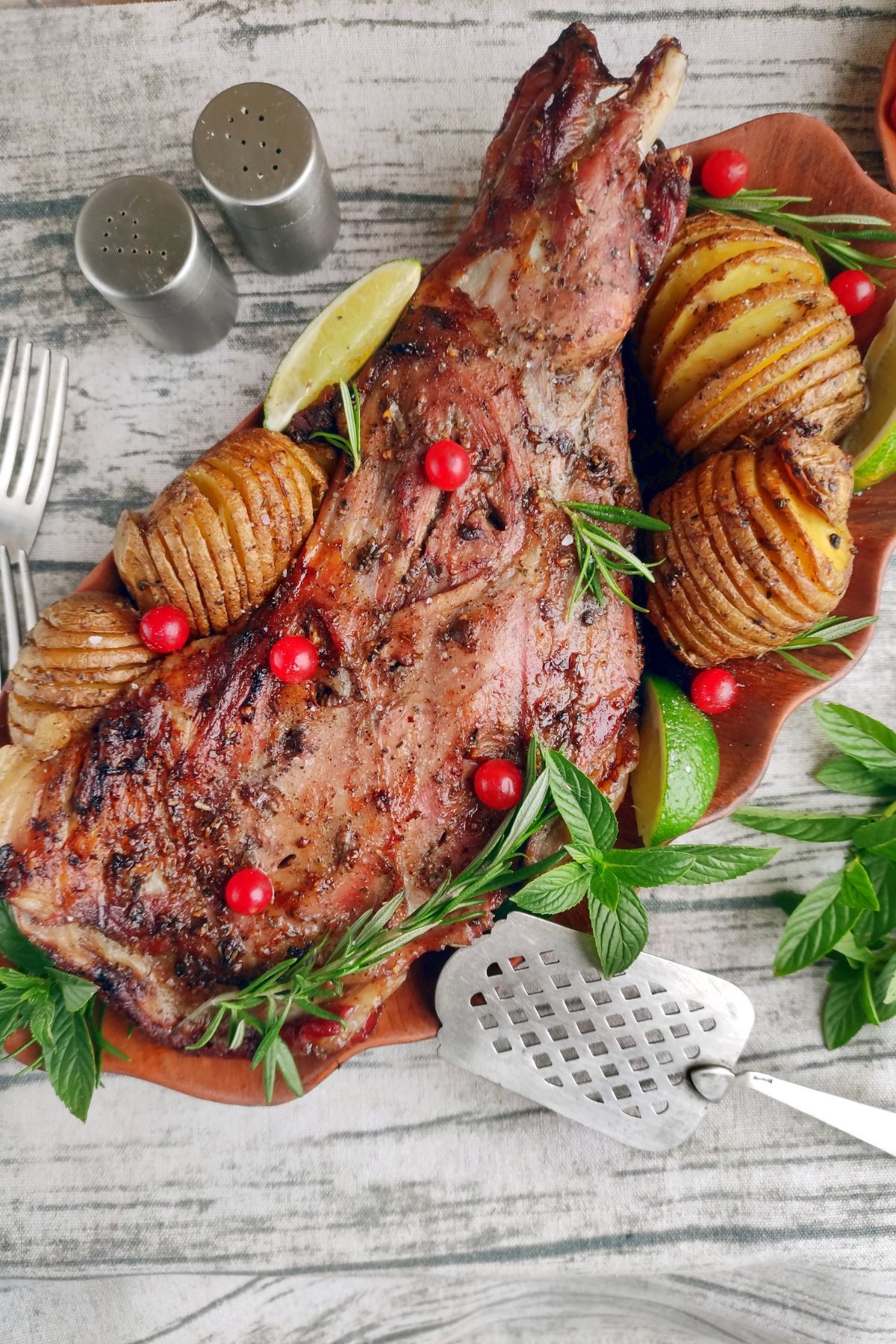 Looking down on a Roasted Leg of Lamb with garnishes.