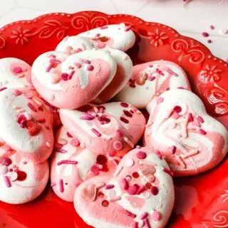 A plate of soft Valentine's Day Meringue Cookies in the shape of a heart.
