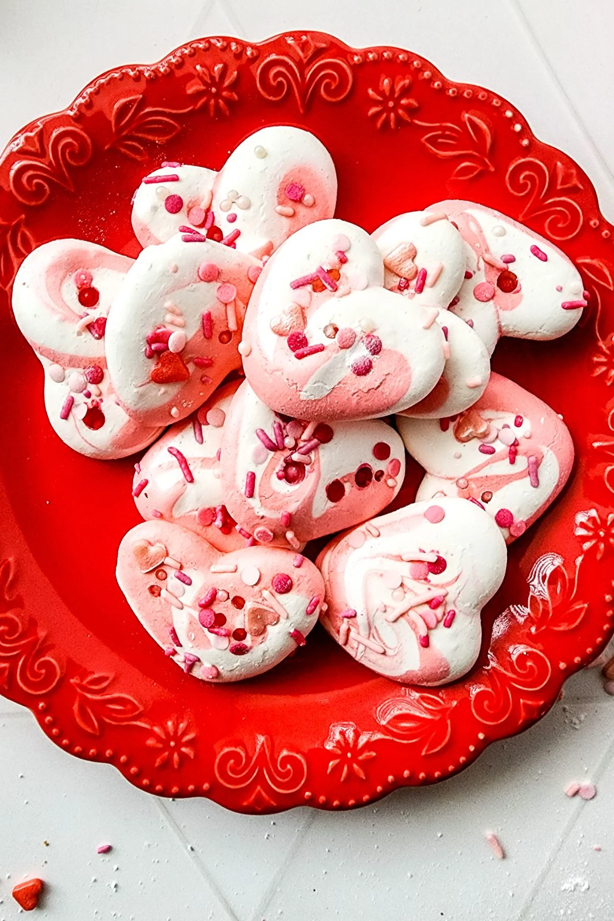 A plate of pink and white meringue cookies.