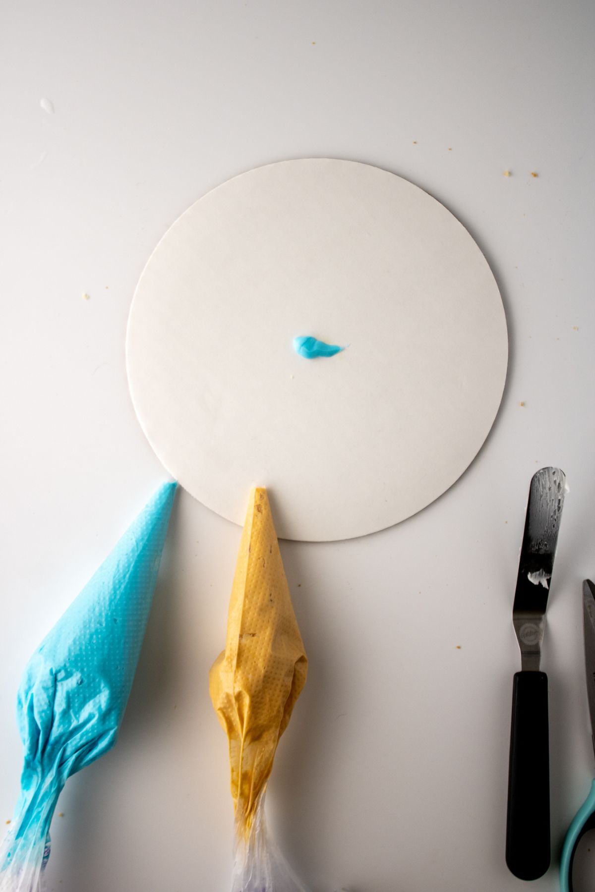 A dot of frosting on a cake board.