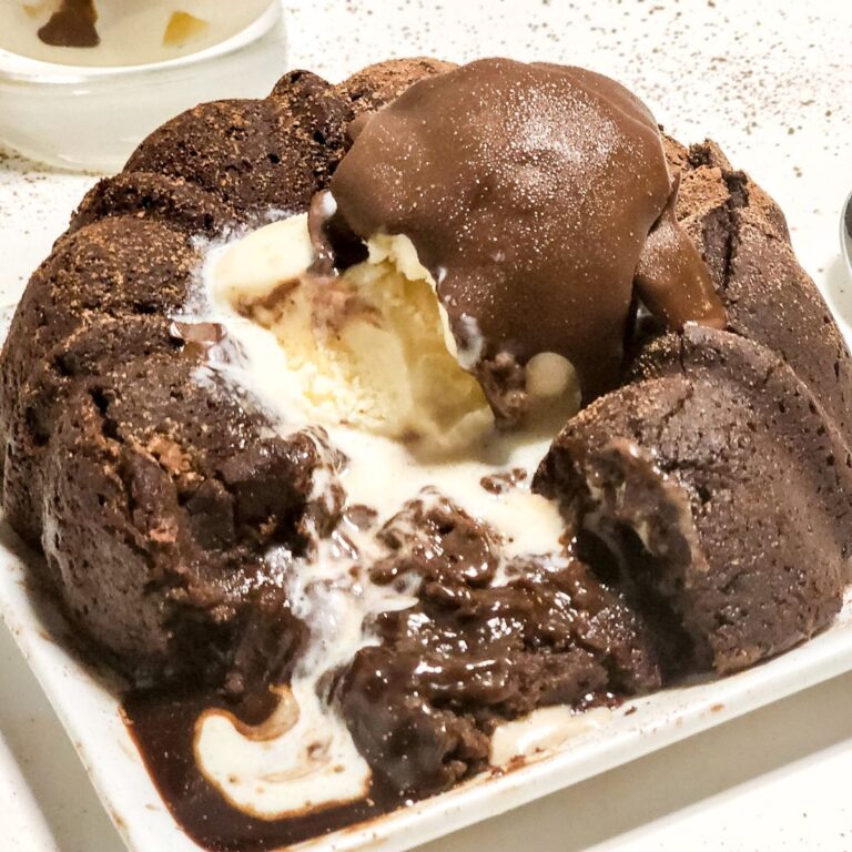 A plate with a chocolate molten lava cake with ice cream and homemade dairy free magic chocolate.