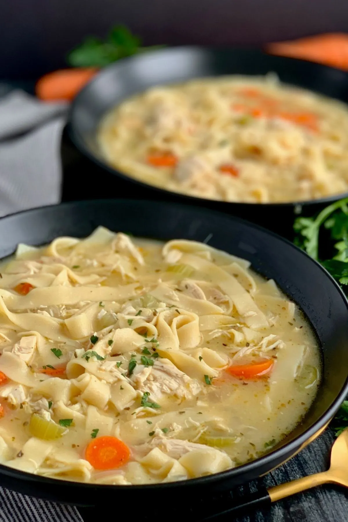 Two bowls of homemade gluten and dairy free chicken noodle soup with egg noodles. 