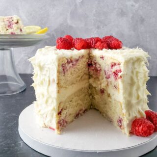 A lemon raspberry gluten and dairy free cake on a cake table.