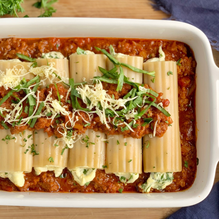 A large white baking dish of homemade gluten free manicotti.