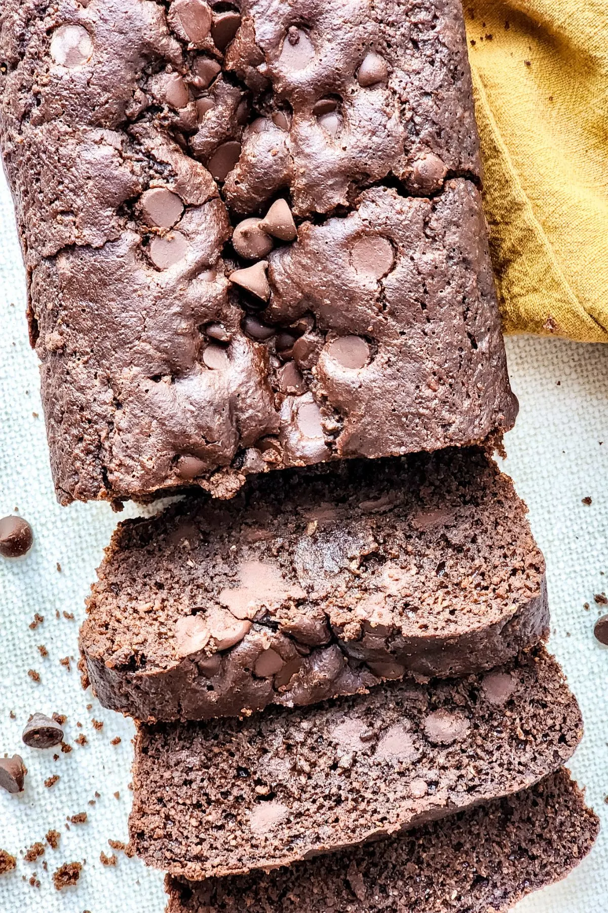 Looking down on a loaf of chocolate zucchini bread with a few pieces sliced off.