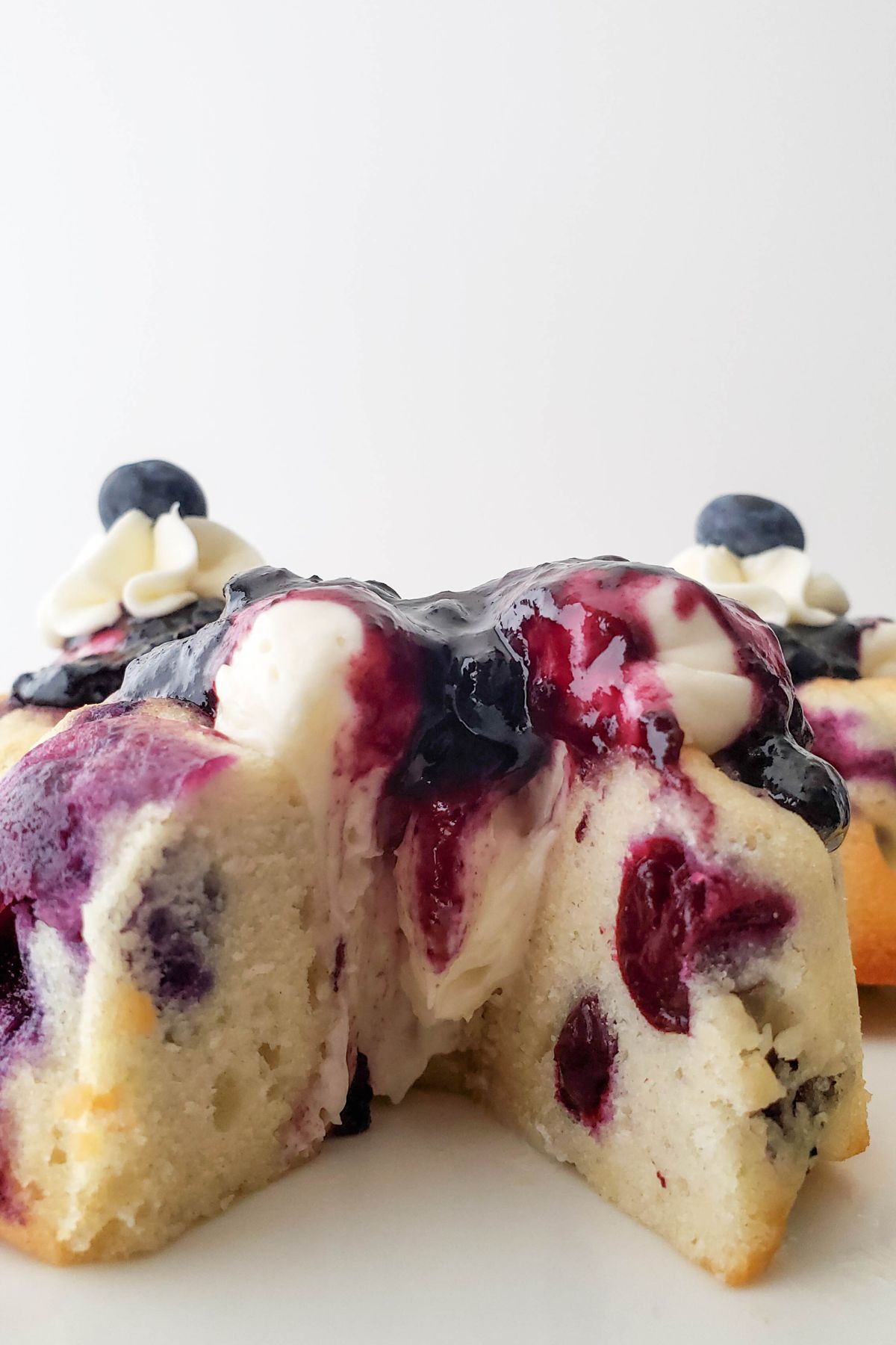 A lemon blueberry mini bundt cake cut open with a slice taken out.