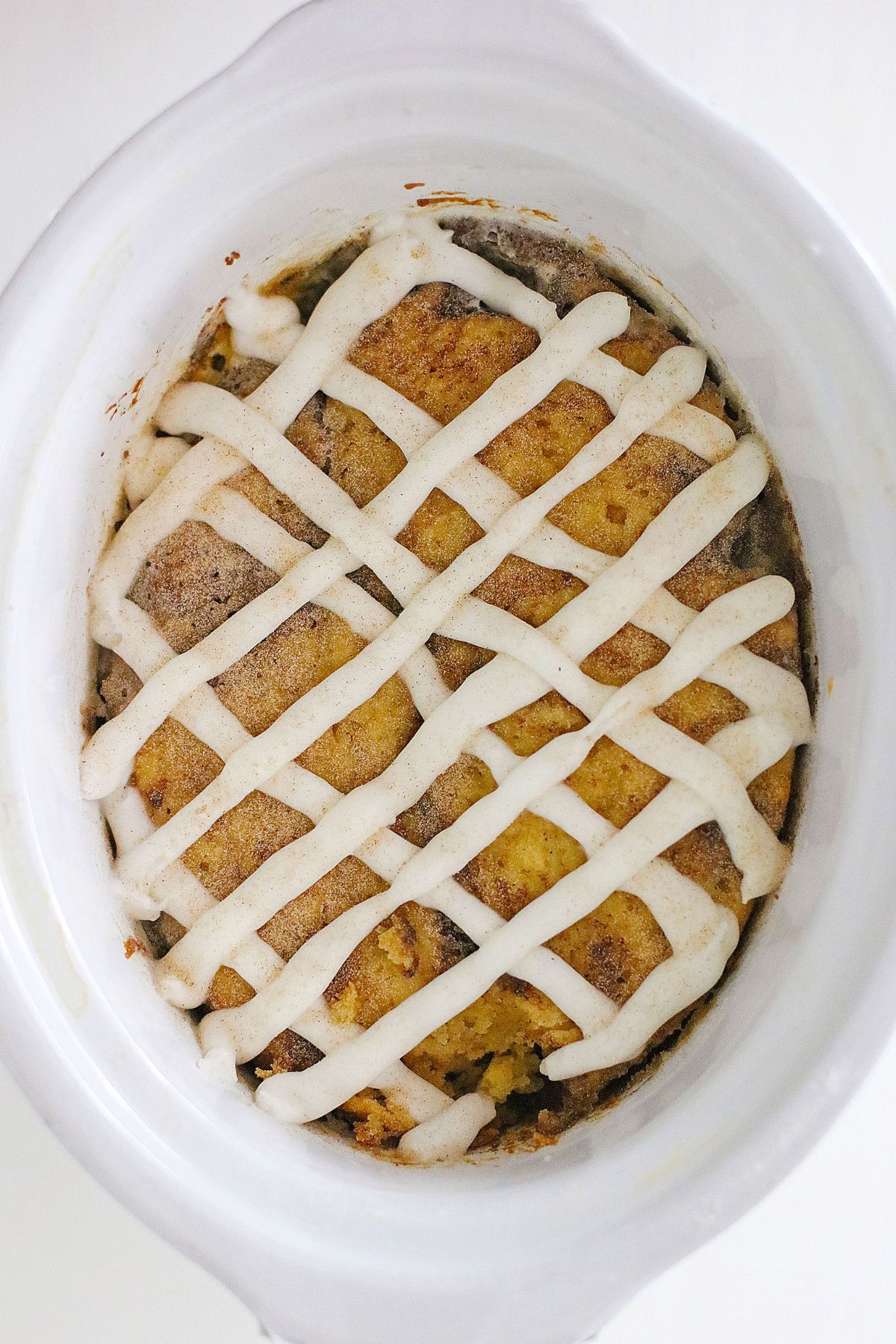 Looking down on a cinnamon bun cake in a crock pot.