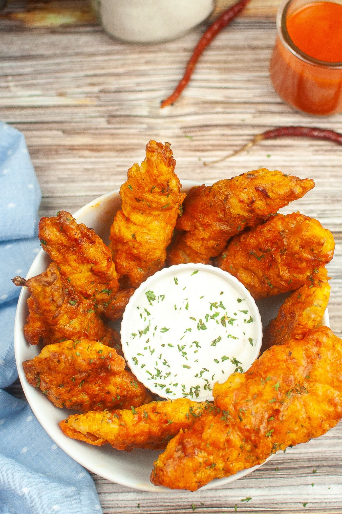 Looking down on a bowl of homemade chicken tenders with dipping sauce.