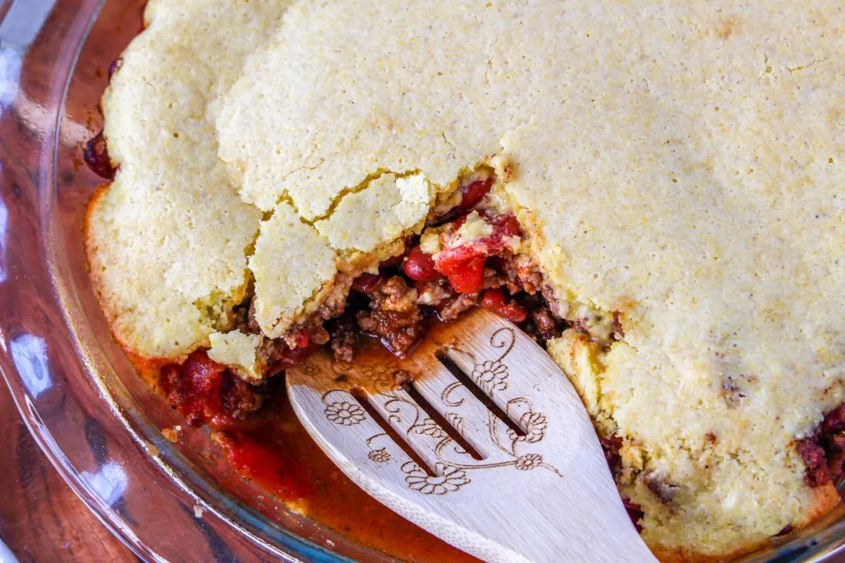 A serving spoon inside of a homemade chili pie.