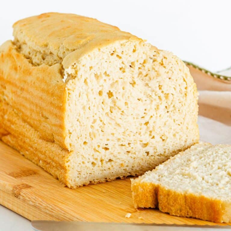 A loaf of gluten free dairy free bread with one slice next to it.