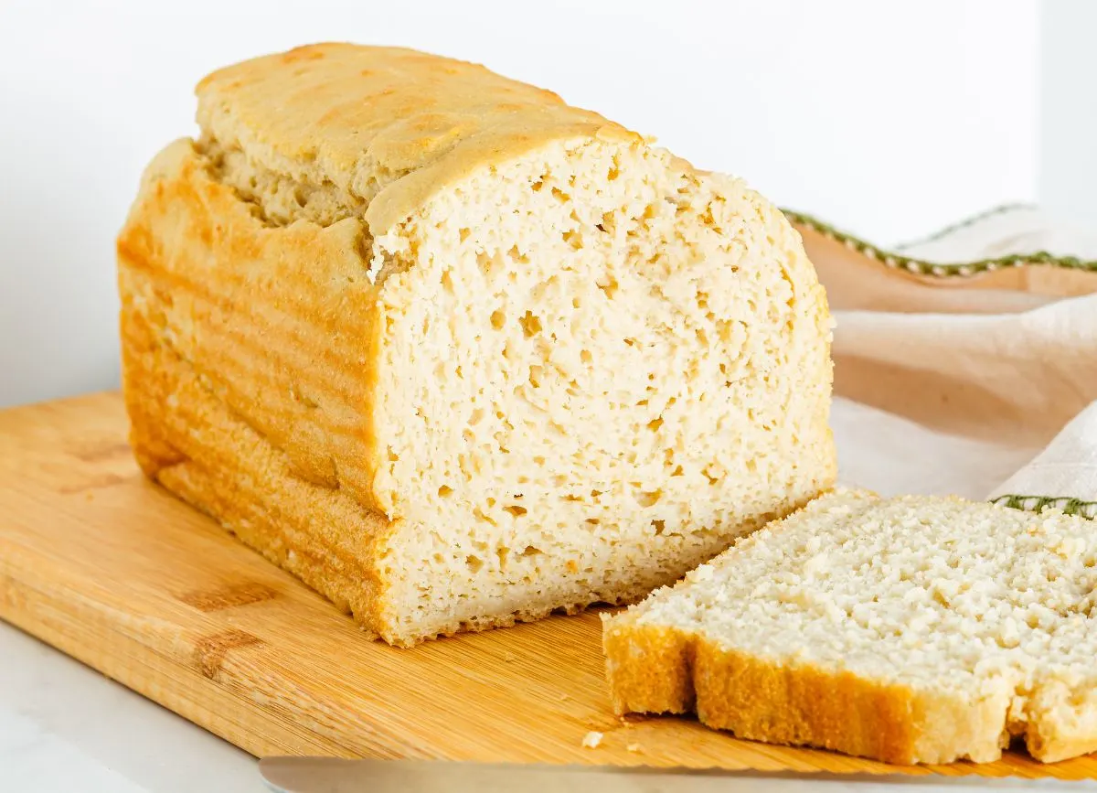 A loaf of gluten free dairy free bread with a slice next to it. 