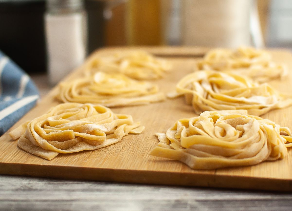 Homemade pasta on a cutting board in nests. 