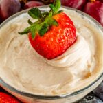 Close up looking at a small bowl of Dairy Free Fruit Dip with a strawberry in it.