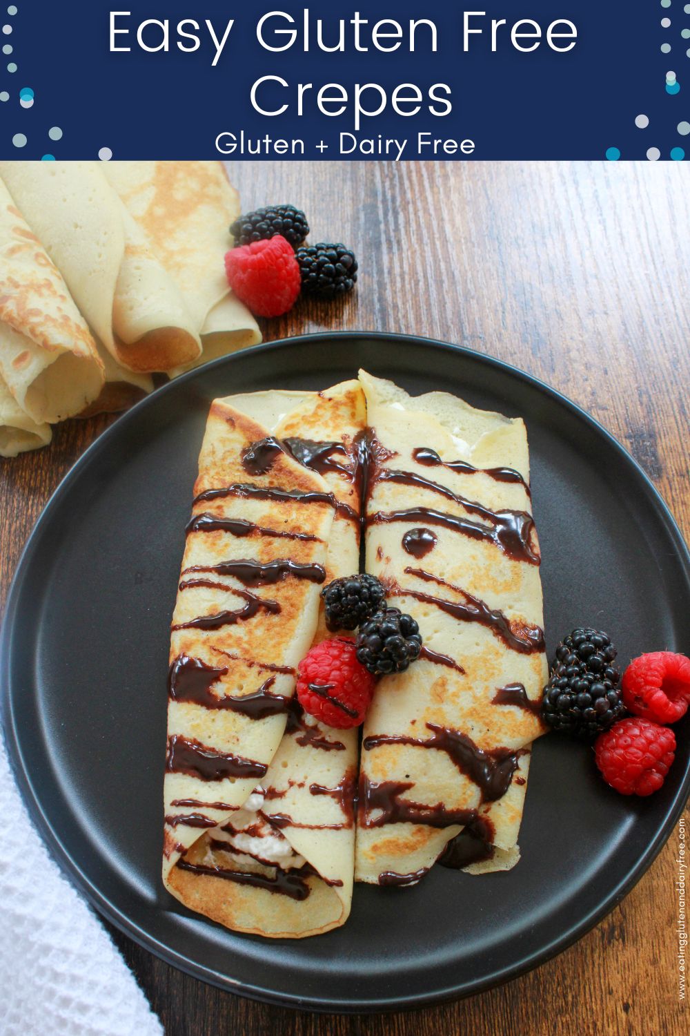 A plate with some gluten free crepes, chocolate sauce, and berries. 