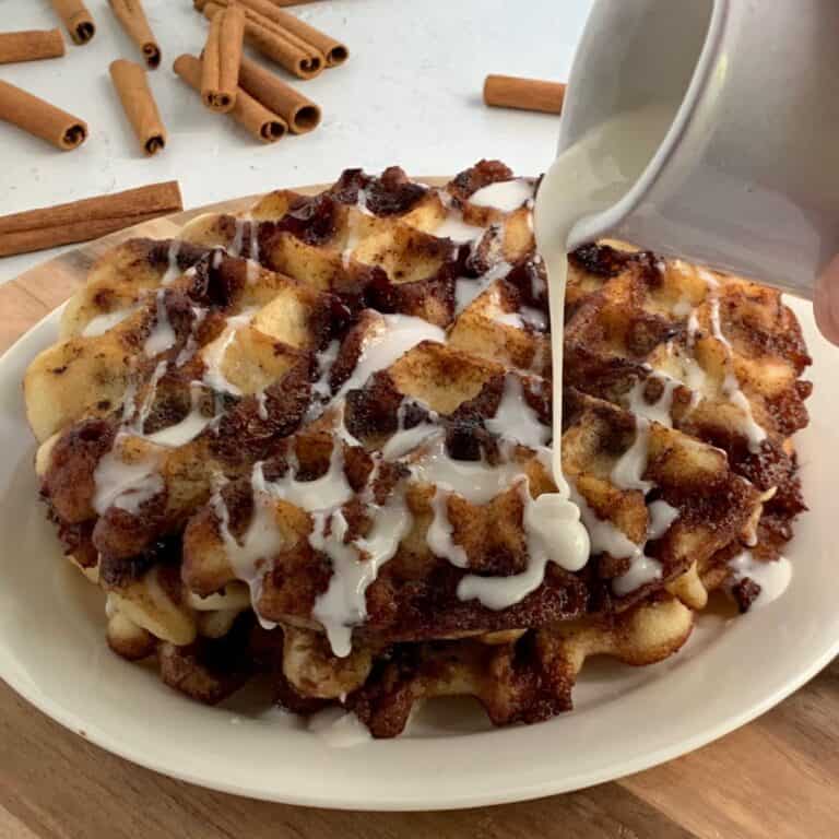 Icing being drizzled on a stack of gluten free dairy free waffles.