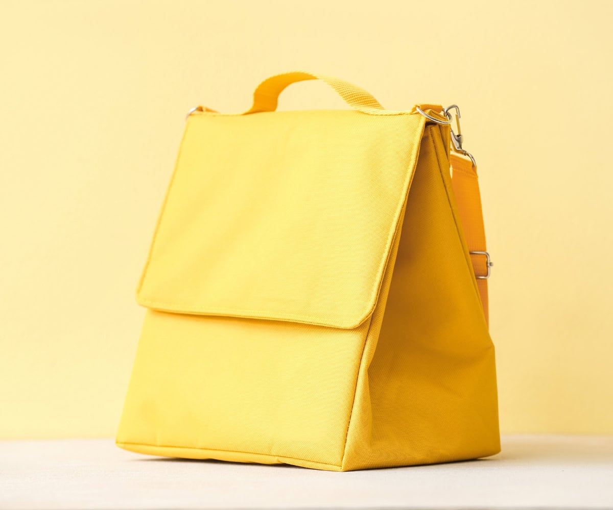 A yellow lunchbox with gluten free and dairy free food.
