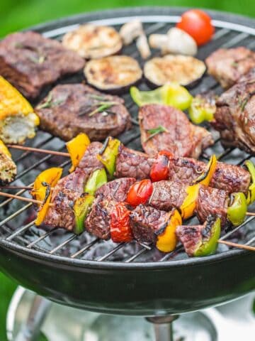A grill with a bunch of food being cooked.